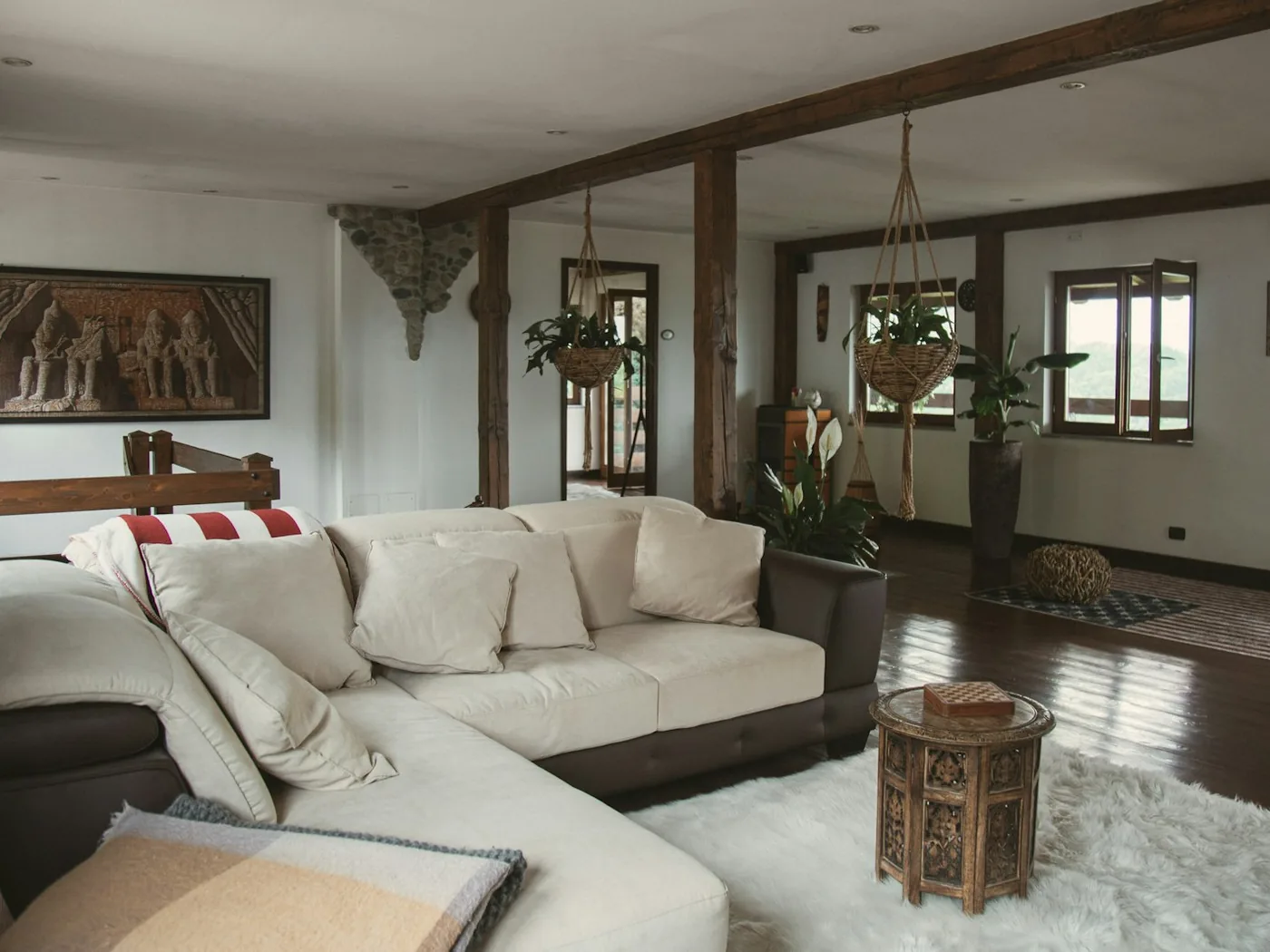 Living de una casa amplia y luminosa, con sillones claros y piso de madera.